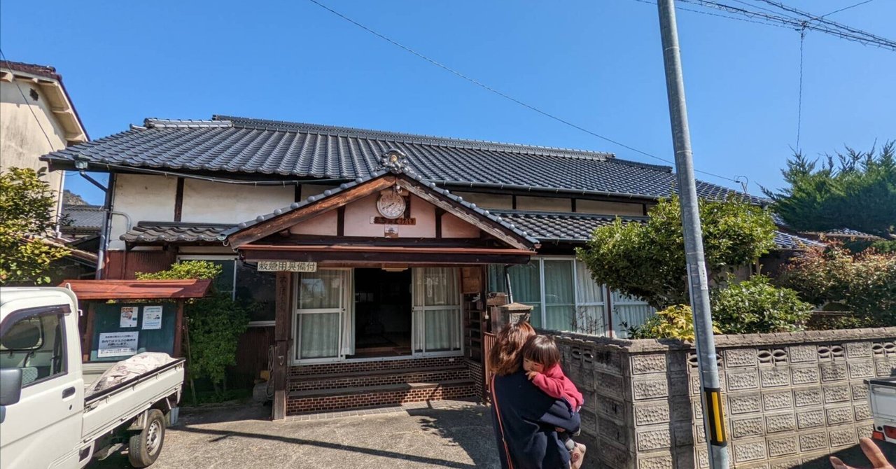 Kakumeisha, the island's schoolhouse, a tile-roofed building with a clock over the entrance.