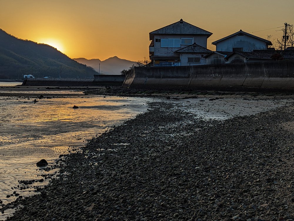 Evening sun low over the sea and a house at Sunoue, Sagishima.